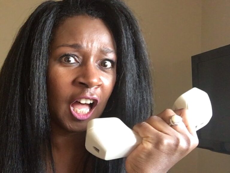 Alicia holding telephone handle up to her mouth in anger